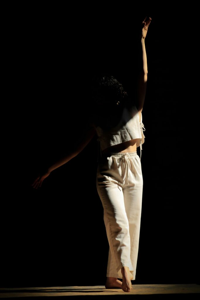 Silhouette of a dancer striking a graceful pose in dramatic lighting, showcasing elegance and motion.